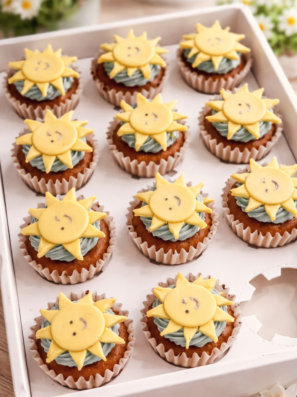 Cupcakes topped with yellow smiling sun decorations